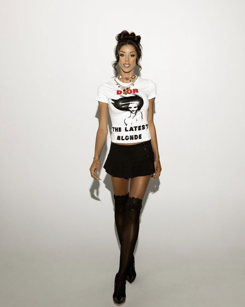 Client in a vintage graphic tee, pleated mini and lace-top stockings