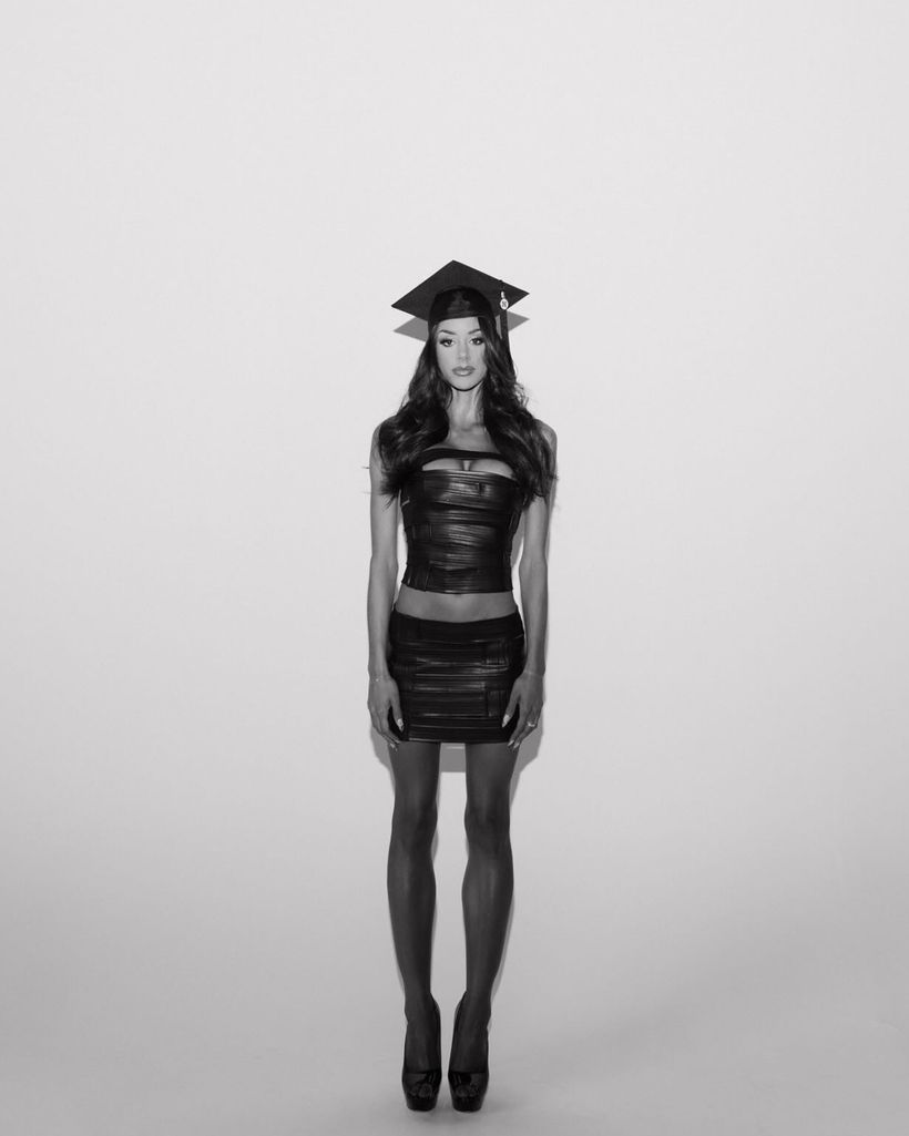 Client in a black leather wrap set and graduation cap, black and white