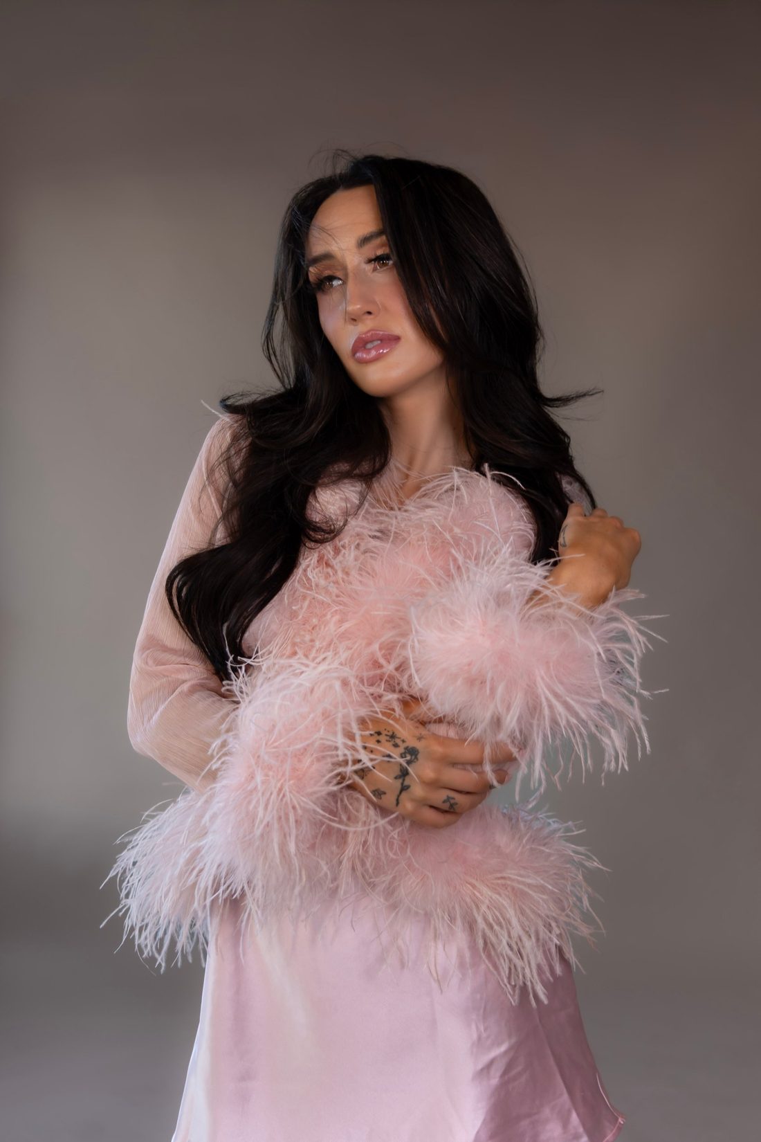 Mackenzie Kern in a pink satin slip with ostrich feather trim