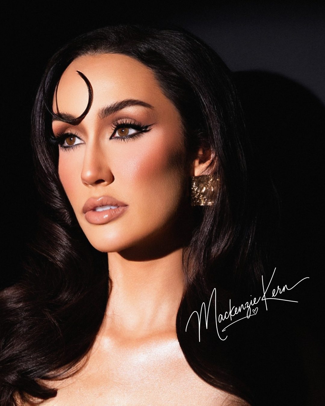 Mackenzie Kern in old-Hollywood glam with a sculpted curl and gold earring, signed